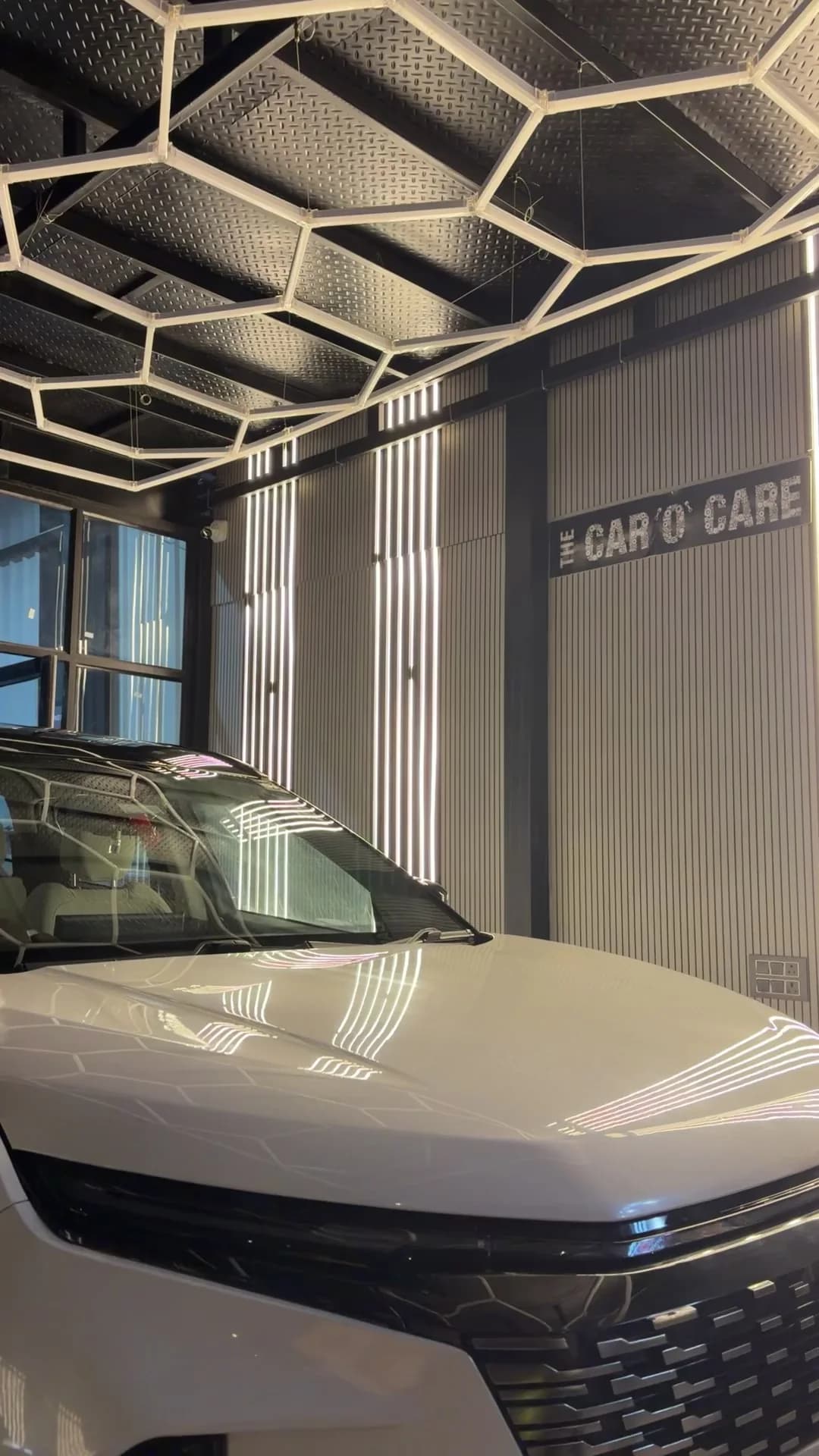 White car staged under studio lighting for ceramic coating and PPF at THE CAR O CARE