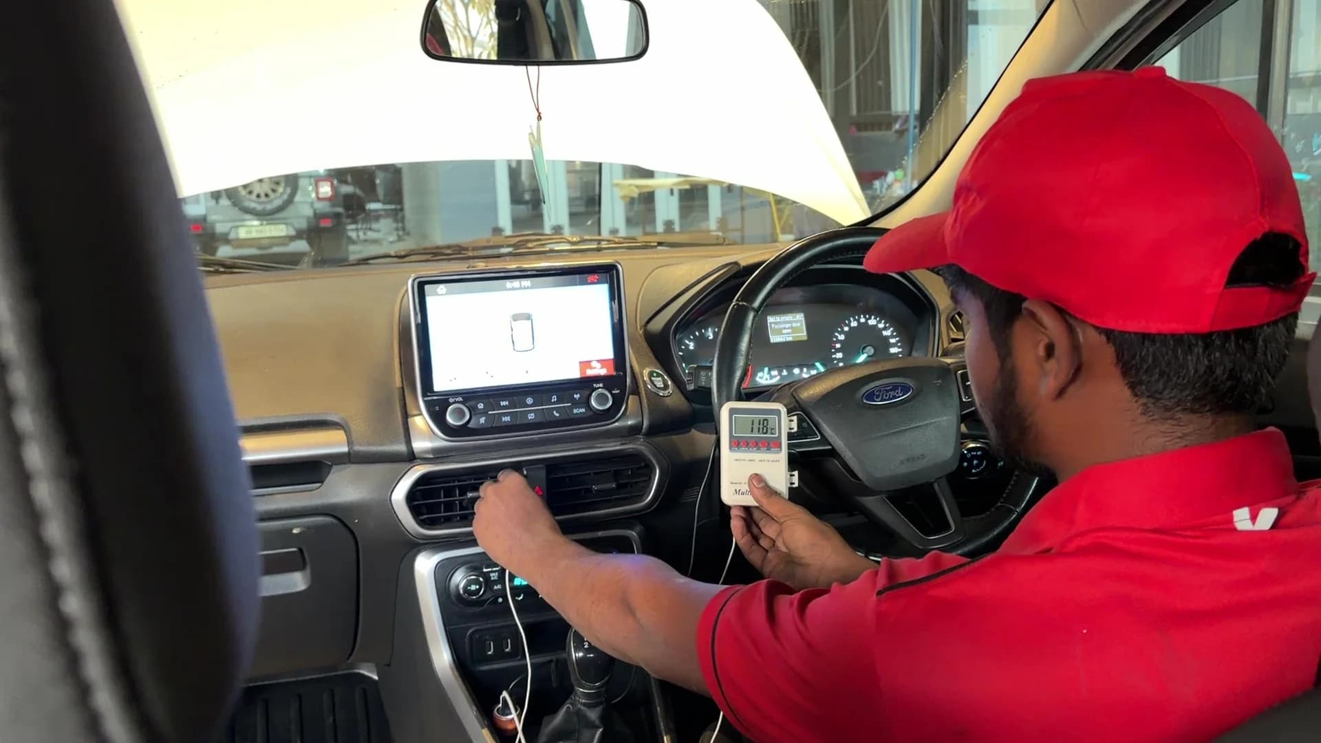Technician checking car AC performance from the dashboard at THE CAR O CARE