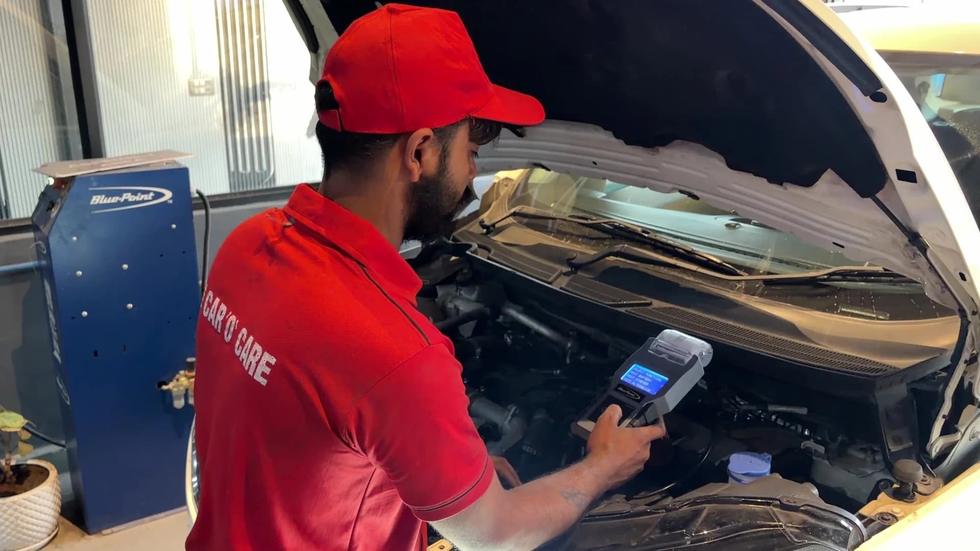 Technician using digital diagnostic equipment in the workshop