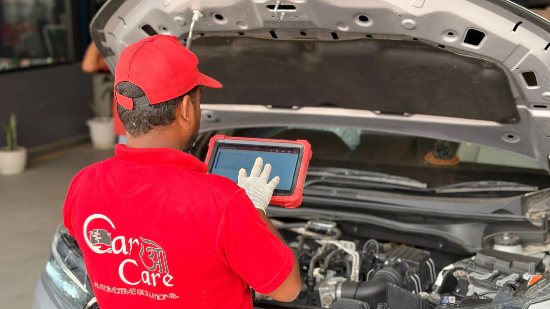 Technician running engine diagnostics with a laptop at THE CAR O CARE service bay