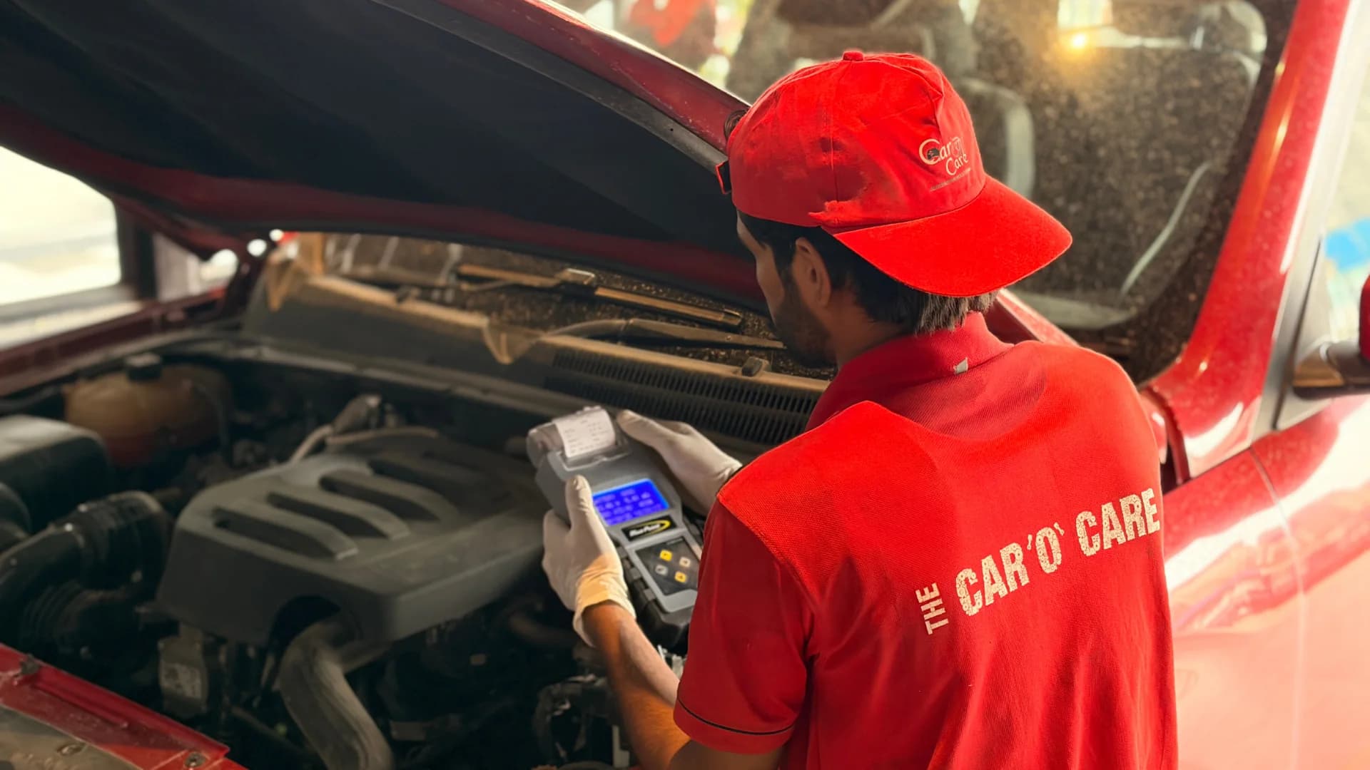 Technician using a scanner for electrical diagnostics under the bonnet at THE CAR O CARE