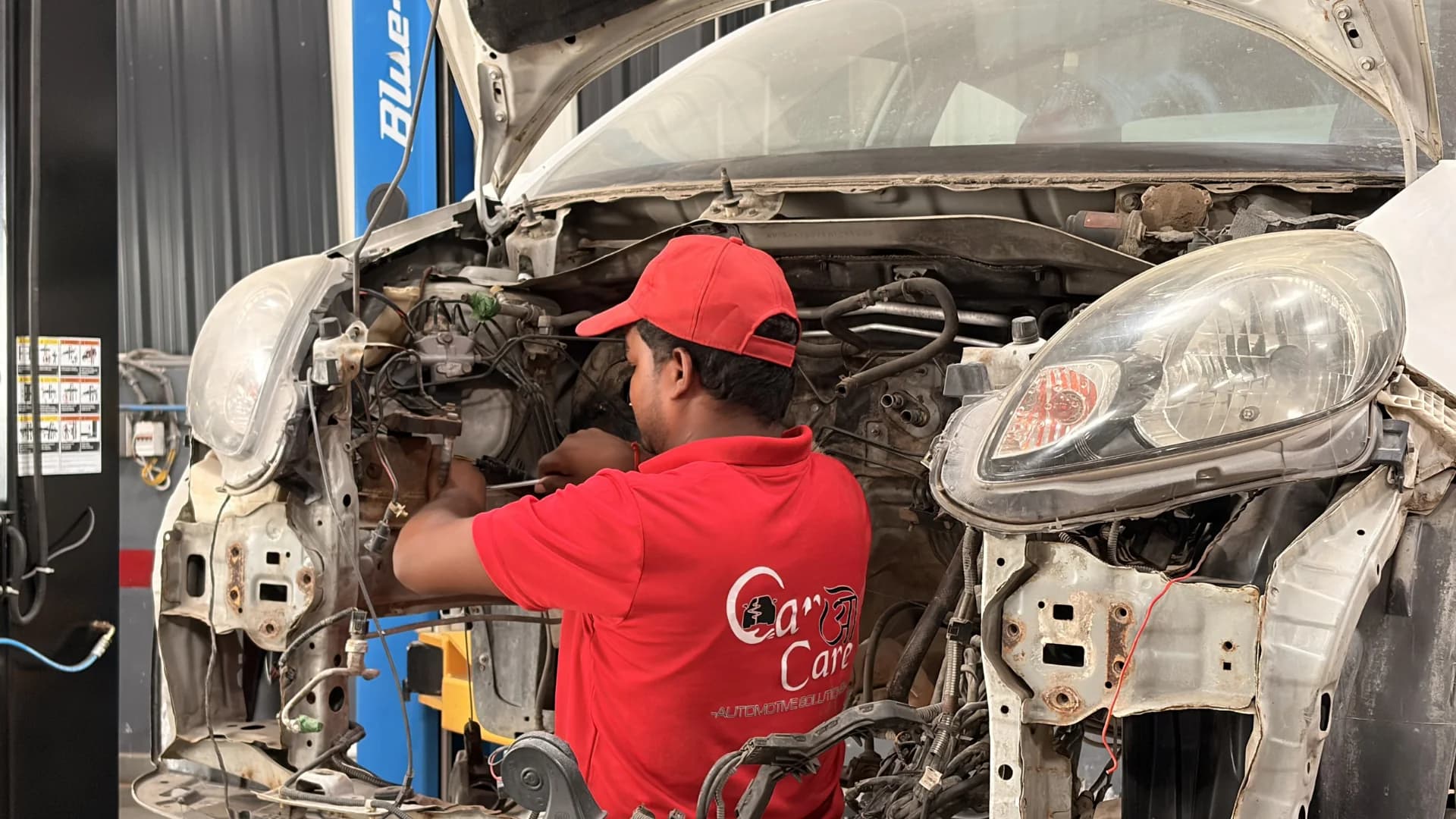 THE CAR O CARE technician performing front-end mechanical repair on a premium car in Noida
