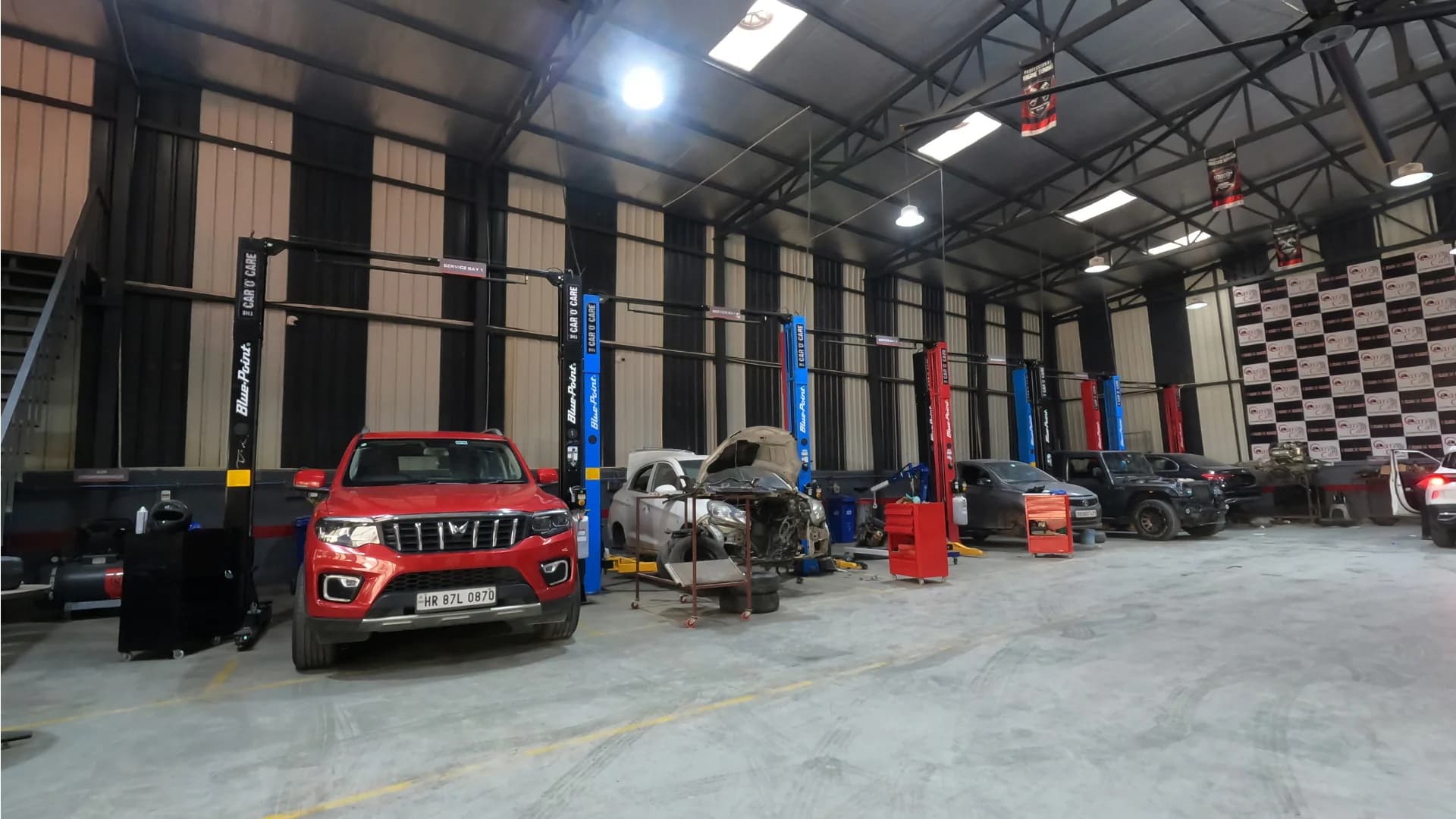 Wide service bay with cars and lifts at THE CAR O CARE